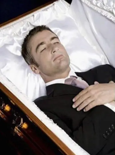 A man lying in a coffin